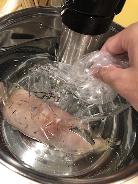 袋に入れた鶏むね肉を水に浸ける